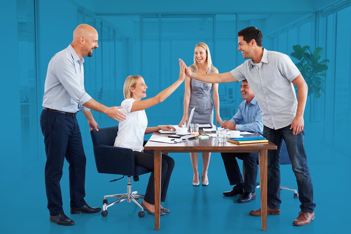 Team collaborating around a laptop in a modern studio